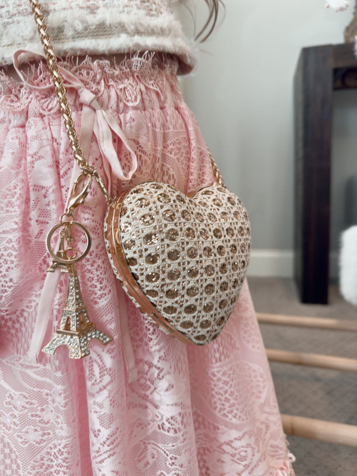 Girl wearing gold heart shaped purse with textured fabric and chain strap
