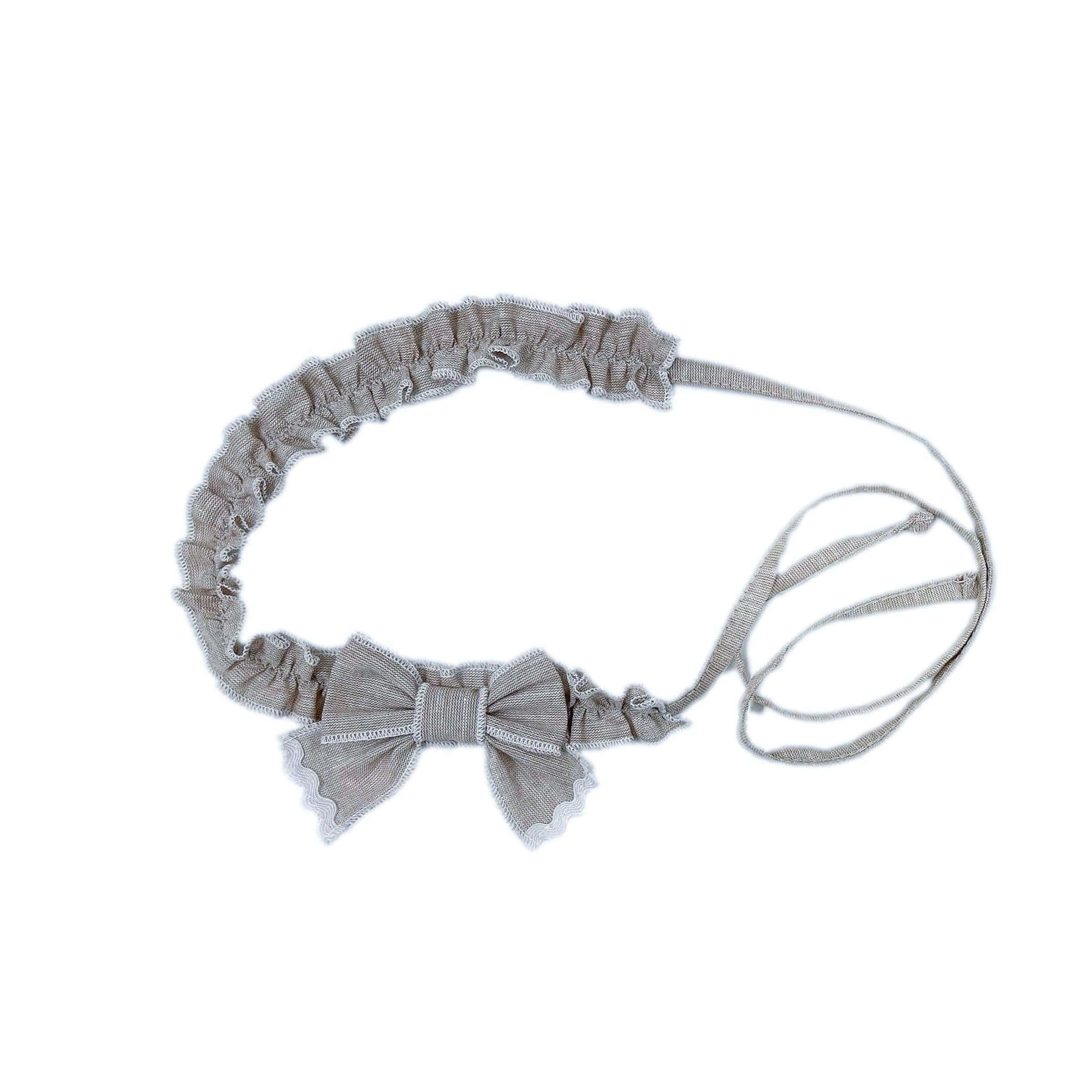 Ashlyn beige linen hair sash with ruffle trim, petite bow detail, white stitching, and adjustable ties from the Ashlyn Collection.