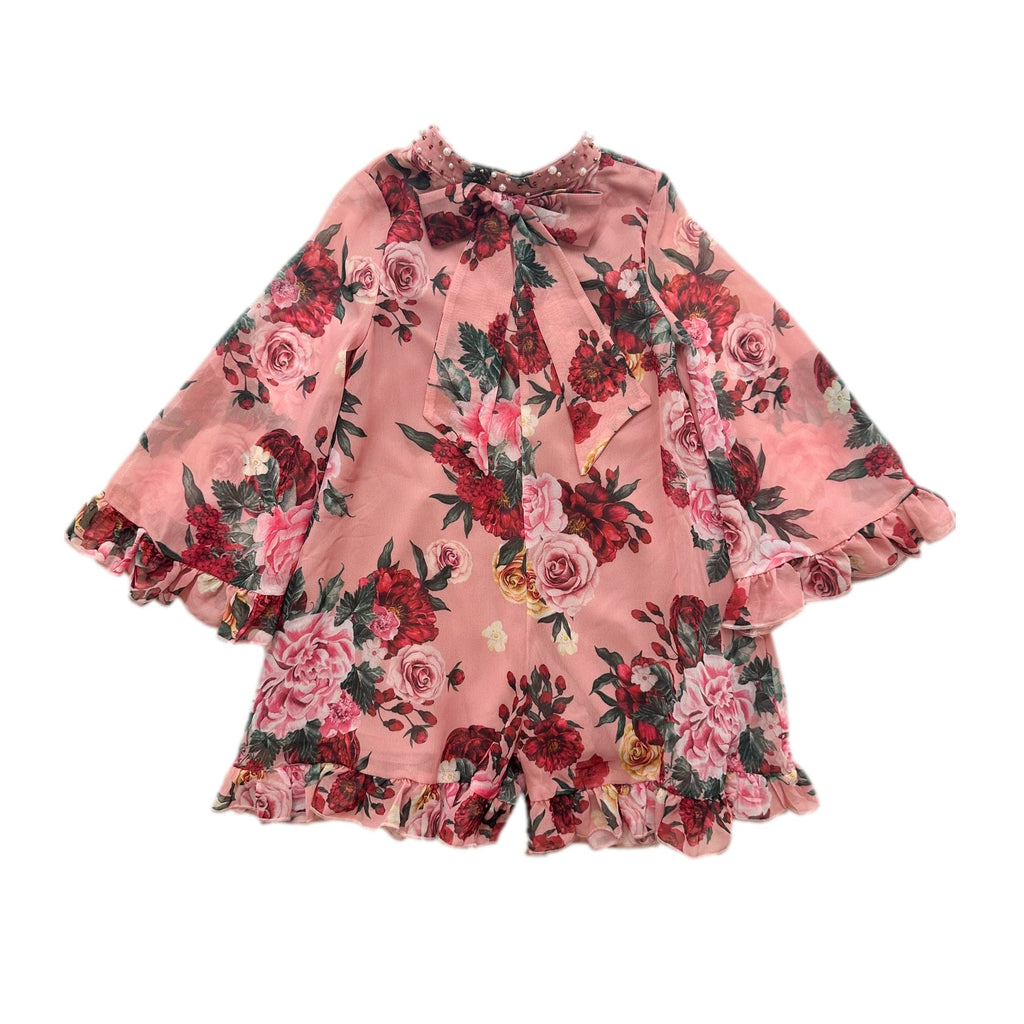 Flora pink floral print girls jumpsuit with criss cross back, hand beaded pearl neckline, pussycat bow detail, and shorts silhouette.