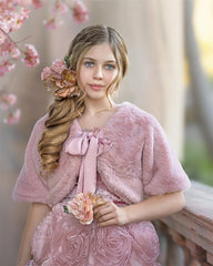 girl in a pink dress wearing pink fluffy faux fur bolero jacket with satin ties
