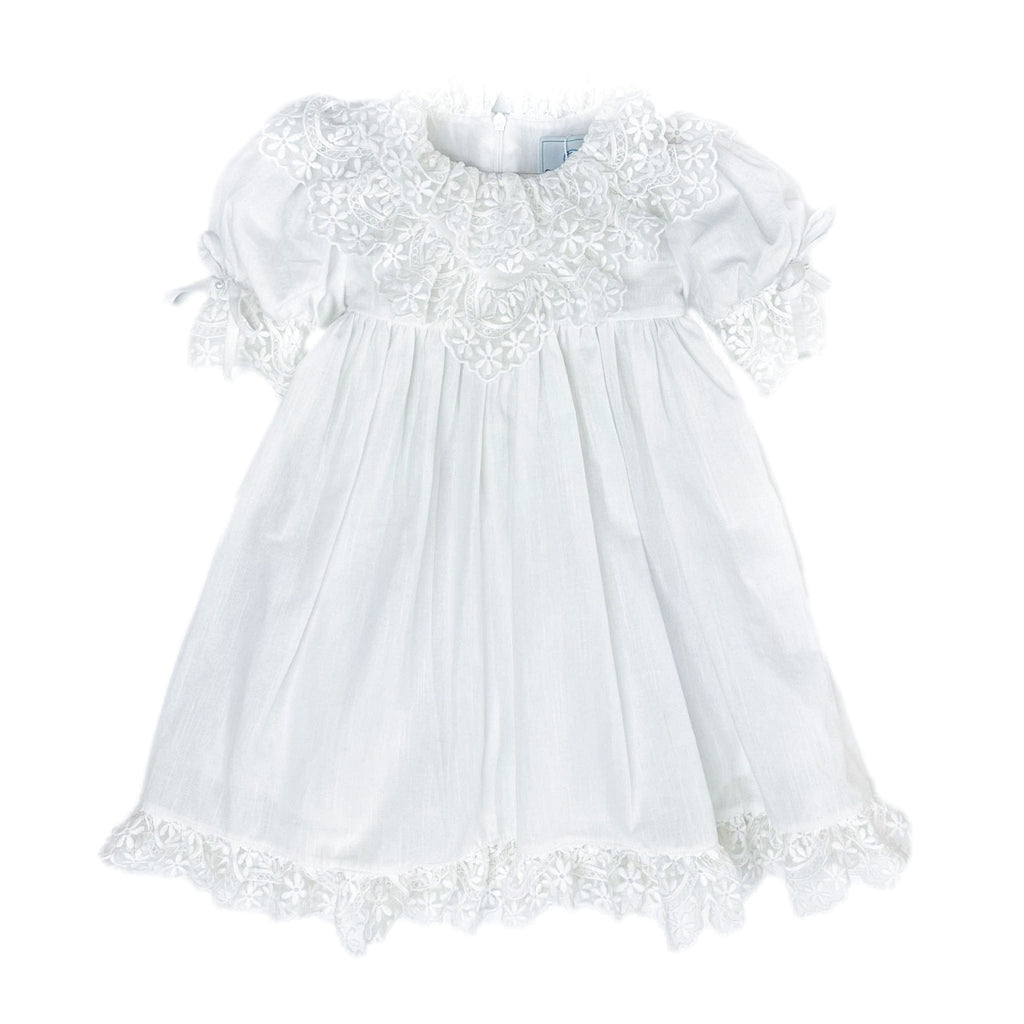Katherine white linen girls dress with embroidered lace detail, large back tie bow, below the knee silhouette, and lightweight fabric.