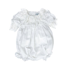 Katherine white linen baby girl romper with embroidered lace detail, large back tie bow, and zipper closure.